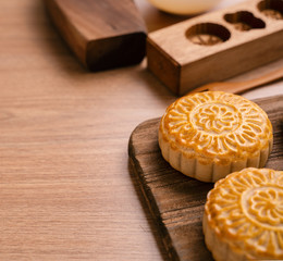Round shaped moon cake Mooncake - Chinese style traditional pastry during Mid-Autumn Festival / Moon Festival on wooden background and tray, close up