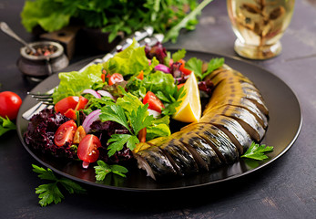 Smoked mackerel and fresh salad on dark background.