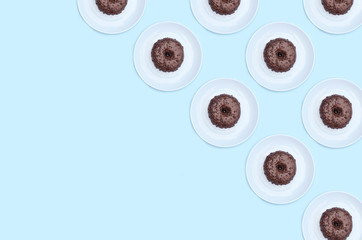 Chocolate donut pattern on a plate on a blue background.