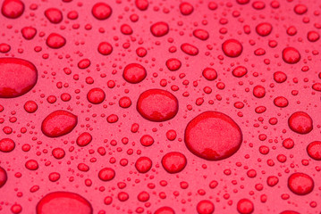 Drops of water on a red metal floor
