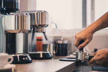 man prepares coffee, tampers coffee beans at home.