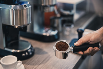 man grinding fresh coffee with coffee machine.