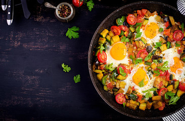 Late breakfast - fried eggs with vegetables. Shakshuka. Arabic cuisine. Kosher food. Top view