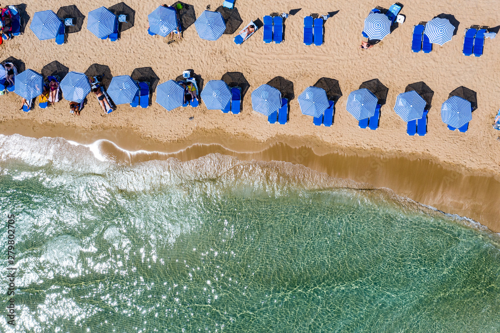 Wall mural aerial view of sandy coast with sandy beach and umbrellas and sunbeds.