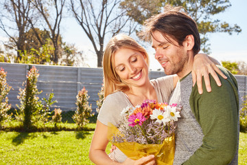 Junge Frau und ihr Freund mit einem Blumenstrauß