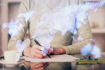 Fototapeta premium International business hologram over woman's hands taking notes background. Concept of success. Double exposure