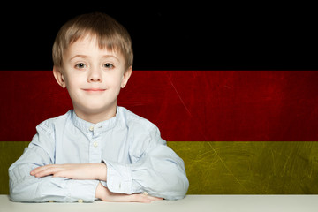 Thinking child boy student against the Germany flag background.