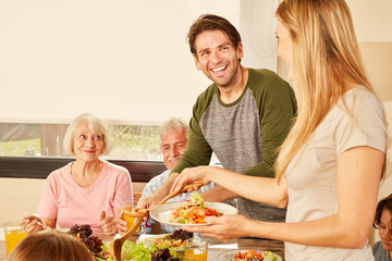 Glückliches Paar mit Großeltern am Esstisch