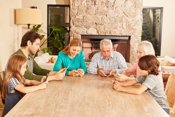 Großfamilie beim Spielen mit Tablet und Smartphone