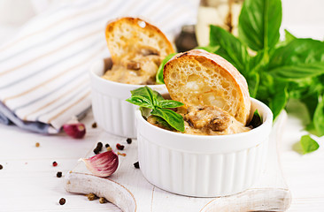 Baked mushroom julienne with chicken, cheese and toast in  pots.