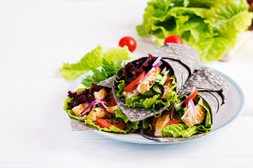 Tortilla with added ink cuttlefish wraps with chicken and vegetables on white background. Chicken...