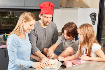 Familie mit zwei Kindern beim Brot backen