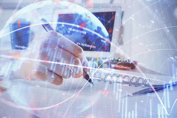 Financial forex graph drawn over hands taking notes background. Concept of research. Multi exposure