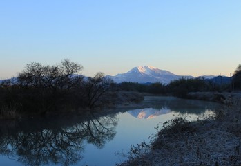 雪化粧した滋賀県の伊吹山と冬の川の景色です