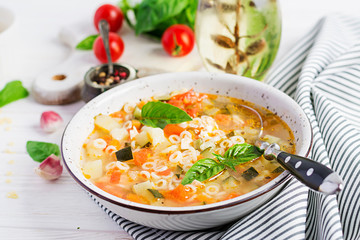 Minestrone, italian vegetable soup with pasta on white table. Vegan soup.