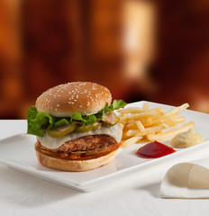 Hamburguesa con queso, jalapeños y patatas fritas. Cheeseburger, jalapeños and fries.