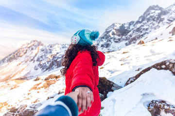 A tourist enjoys snowfall at Chopta valley, Kalapathar in North Sikkim, India in cold winter. Snow covered mountain peaks in north east part of India. Girl in Red jacket