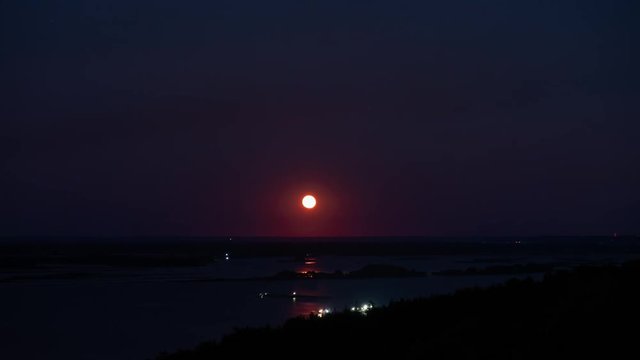 Full moon rising over night river valley