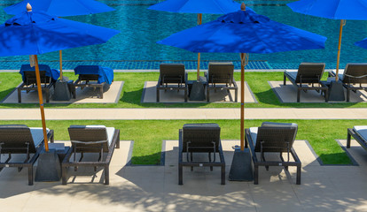 Daybed sun lounger chair by poolside with towel and umbrella