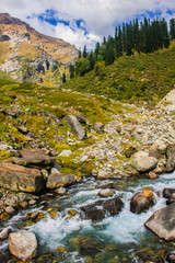 Trekking through green valleys & meadows in the Himalayan mountain range in Manali, Himachal pradesh , India. Beautiful turquoise colored waterfalls & pine trees. Pure Himalayan water