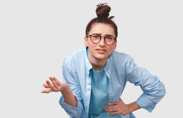 Displeased young woman, looking doubtful at discussing important decisions, gesturing with hand,...