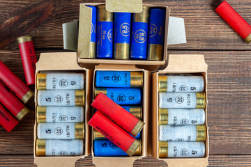 12 gauge caliber color cartridges hunting shells in a box pack on a brown wooden background
