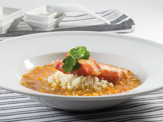  Arroz con bogavante y perejil en plato de porcelana blanca, receta gourmet.. Rice with lobster and parsley in a white porcelain plate, gourmet recipe.