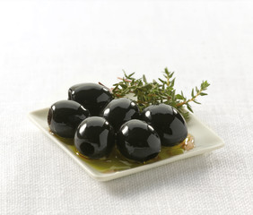 Olivas negra, aceite con romero. Sobre fondo blanco. Black olives, oil with rosemary. On white background.