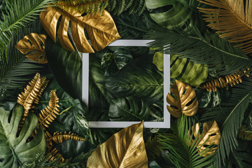 Creative nature background. Gold and green tropical palm leaves. Minimal summer abstract jungle or...