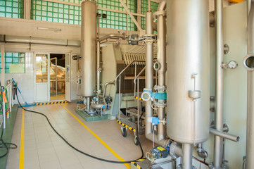 Equipment for preparation of beeer..Lines of metal tanks in modern brewery. Manufacturable process of brewage. Mode of beer production. Inside view of modern brewhouse with stainless barrels