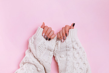 Woman's hands in warm knitted sweated with beautiful manicure