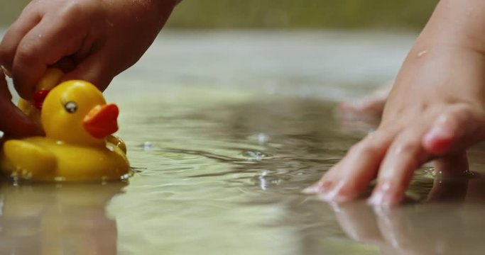 Mother and child play with rubber ducks on open air