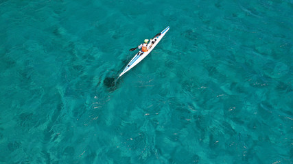 Obraz premium Aerial drone photo of fit men practising sport canoe in tropical open ocean bay with turquoise clear sea