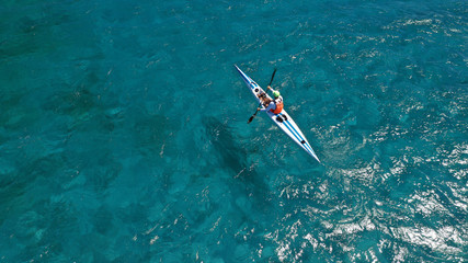 Aerial drone photo of fit men practising sport canoe in tropical open ocean bay with turquoise...