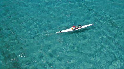 Aerial photo of fit athletes competing on sport canoe in tropical exotic bay with crystal clear turquoise sea