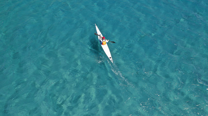 Aerial photo of fit athletes competing on sport canoe in tropical exotic bay with crystal clear turquoise sea