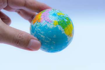 Hand holding globe over white background. Copy space for text.