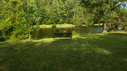 Fototapeta na wymiar Sitting chair near the lake in the green field . 