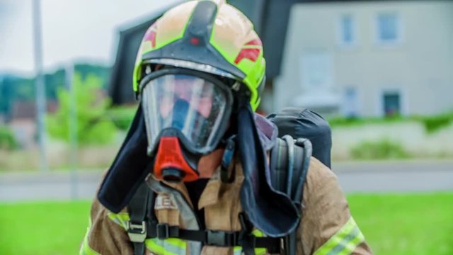 A firefighter is putting on a protection helmet before going into a firefighting operation.