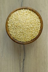 A flat lay image of a bowl of quinoa on a wooden background surface with copy space for your text
