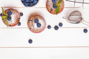Delicious muffins with blueberries on the white wooden table