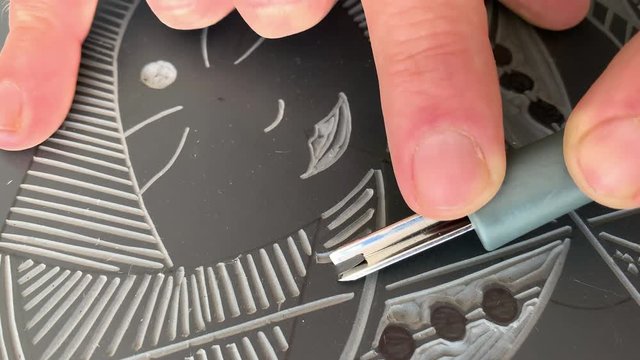 Hands cutting a Lino Cut.