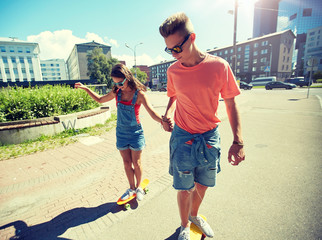 summer holidays, extreme sport and people concept - happy teenage couple riding short modern...