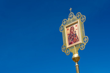 Fototapeta na wymiar banners, procession, the icon of the Iberian mother of God on a blue sky background, copy space