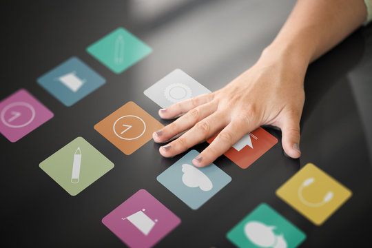 Technology And People Concept - Hand Using Interactive Panel With App Icons On It