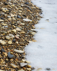 The wave rolls on the rocky shore.