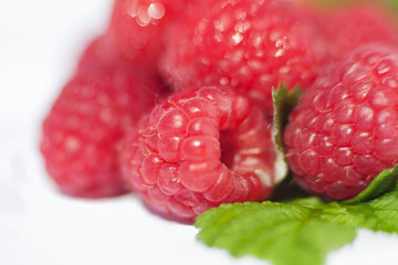 Fresh organic ripe raspberries with green leaf isolated on white background macro.Selective focus