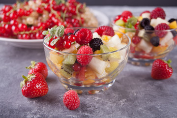 salad with fresh fruits and berries on a bowls on the concreate background