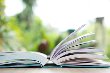 open book on wooden table in nature