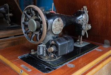 Old and rusty sewing machine on the wooden table in the past of Thailand